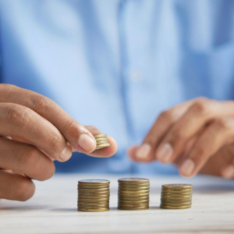 MRP ASESORES Manos apilando monedas sobre una mesa, con atención en el proceso para su hipoteca